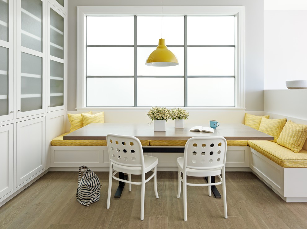 Exemple d'une salle à manger ouverte sur la cuisine chic avec un mur gris et parquet clair.