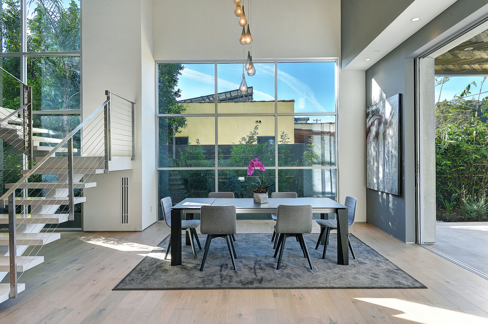 Photo of a contemporary dining room in Los Angeles with white walls, light hardwood flooring and no fireplace.