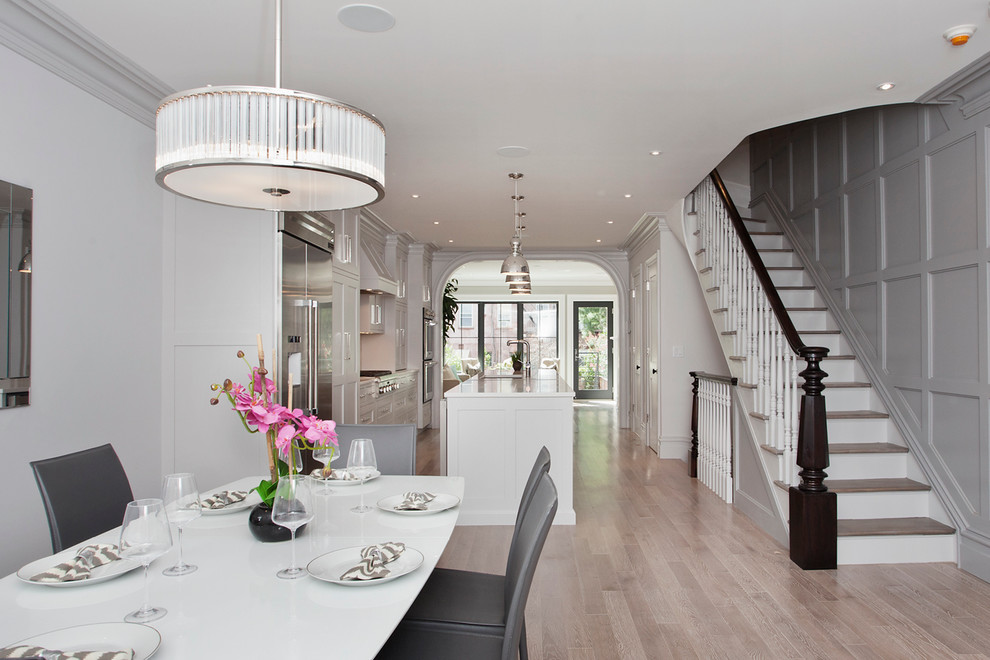 Photo of a medium sized classic open plan dining room in New York with white walls and light hardwood flooring.