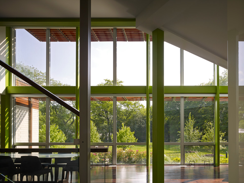 Exempel på en stor modern matplats med öppen planlösning, med gröna väggar, vinylgolv, brunt golv och en dubbelsidig öppen spis