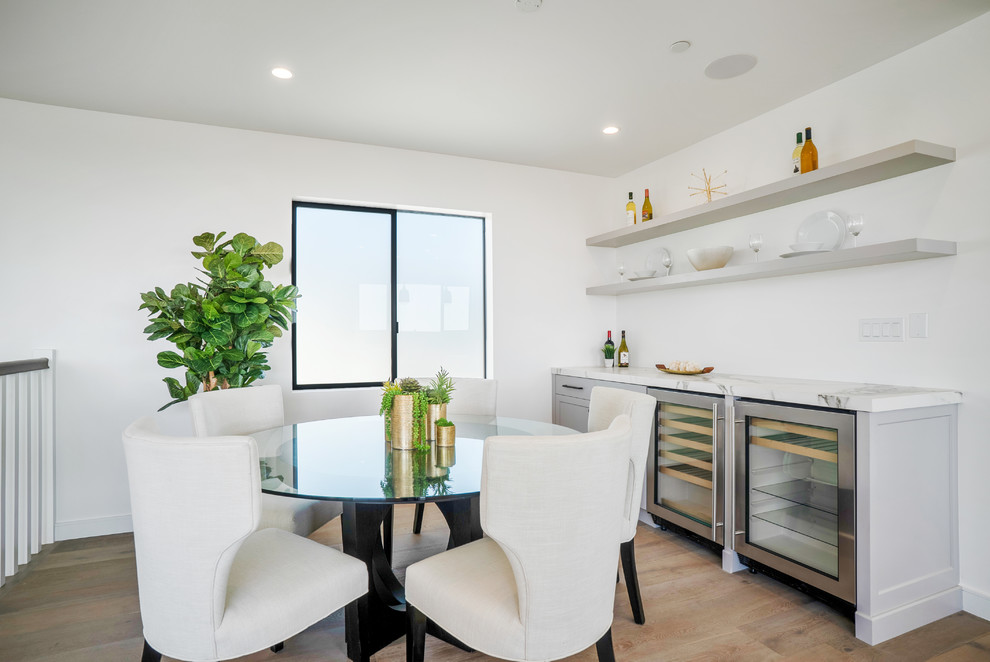Photo of a contemporary dining room in Los Angeles with white walls, medium hardwood flooring, no fireplace and brown floors.
