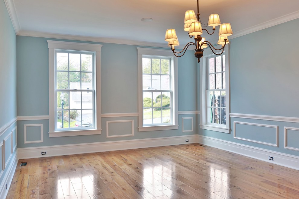 Foto di una sala da pranzo tradizionale chiusa e di medie dimensioni con pareti blu, parquet chiaro e pavimento blu