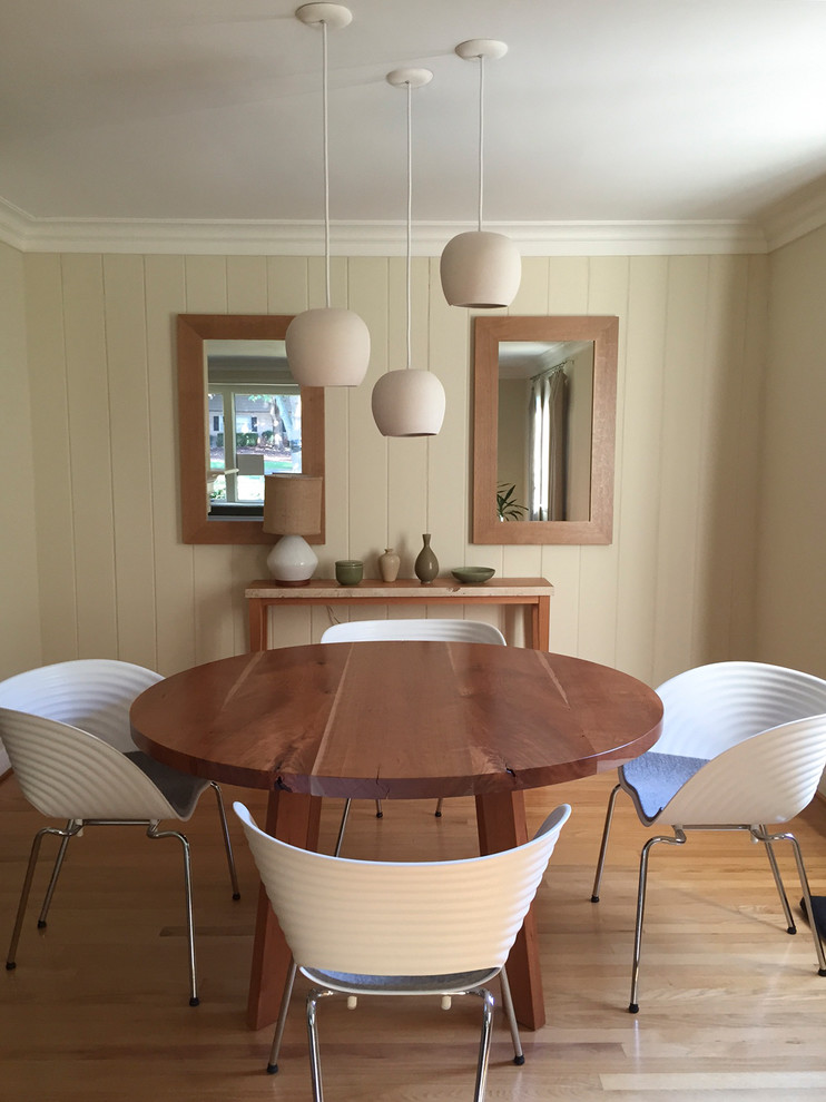 Exemple d'une salle à manger ouverte sur la cuisine moderne de taille moyenne avec un mur blanc et parquet clair.