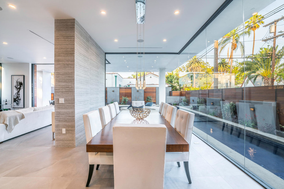 Photo of a large contemporary open plan dining room in Los Angeles with no fireplace, beige walls, concrete flooring and grey floors.