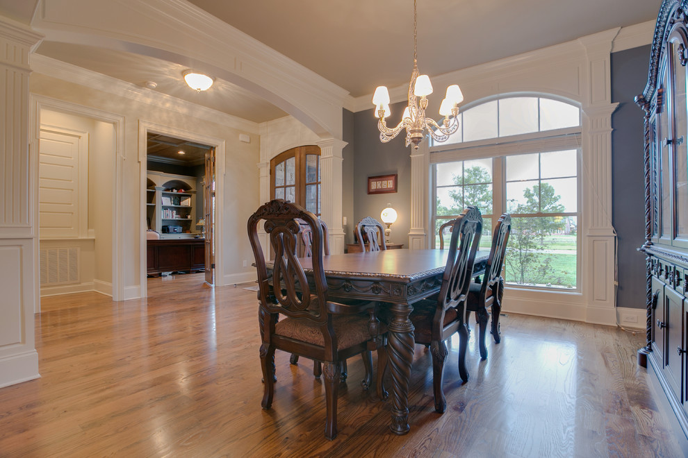 Foto di una sala da pranzo aperta verso la cucina classica di medie dimensioni con pareti grigie e pavimento in legno massello medio