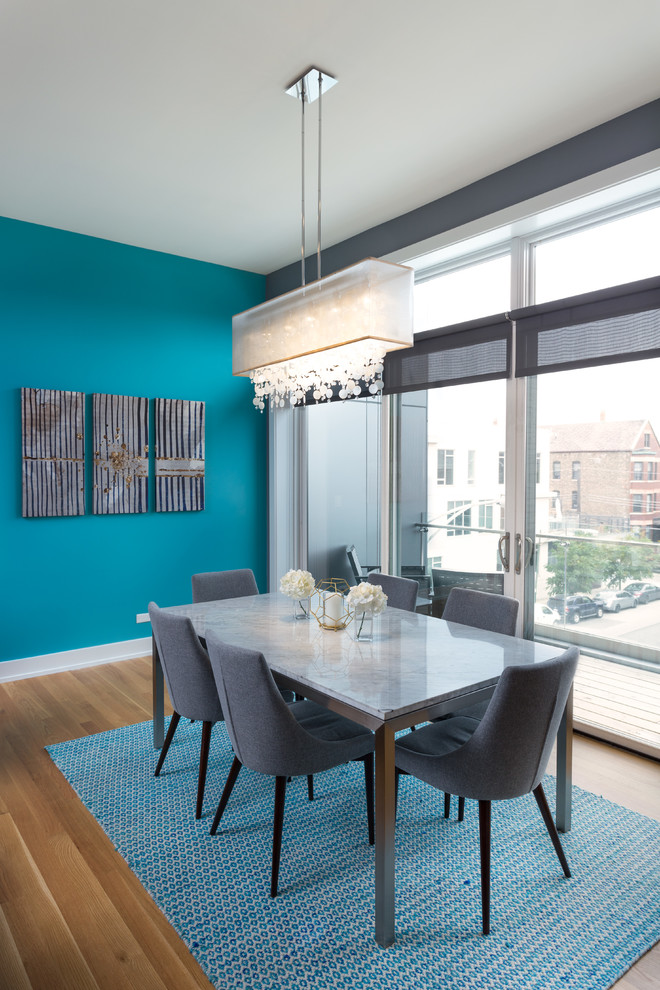 Idee per una grande sala da pranzo aperta verso il soggiorno moderna con pareti blu, pavimento in legno massello medio e cornice del camino in pietra