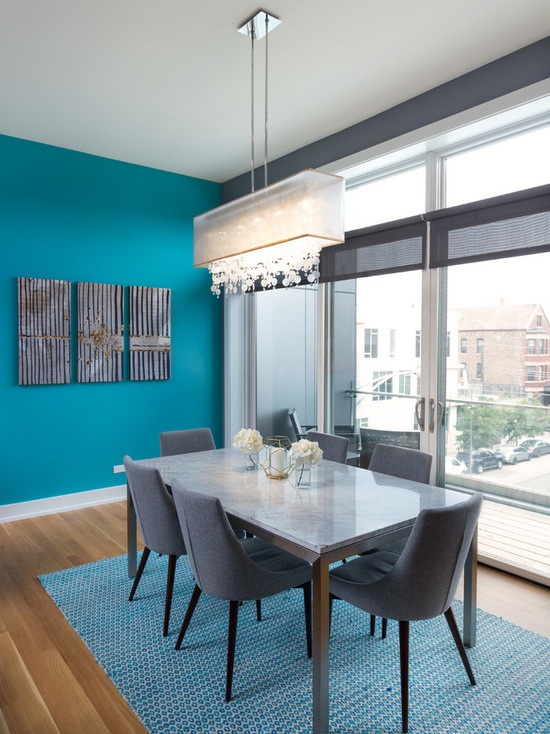 Idée de décoration pour une grande salle à manger ouverte sur le salon design avec un mur bleu et un sol en bois brun.