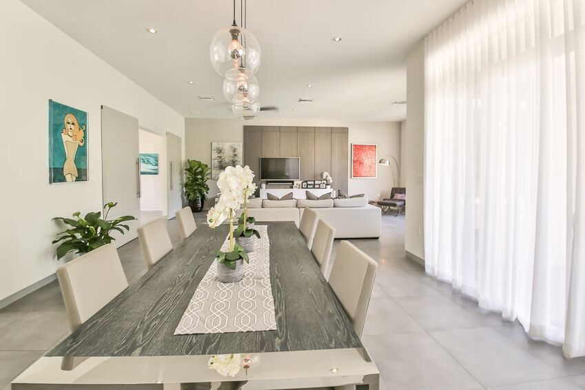 Cette photo montre une salle à manger ouverte sur le salon tendance avec un mur beige, un sol en carrelage de porcelaine et un sol gris.