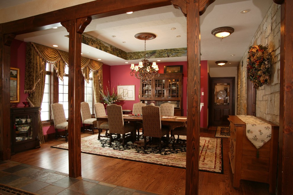 Modelo de comedor clásico extra grande cerrado con paredes rojas y suelo de madera en tonos medios