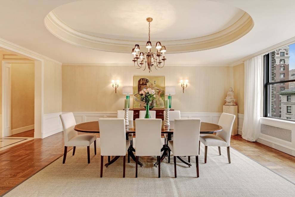 Immagine di una sala da pranzo tradizionale con pareti beige, pavimento in legno massello medio e pavimento marrone