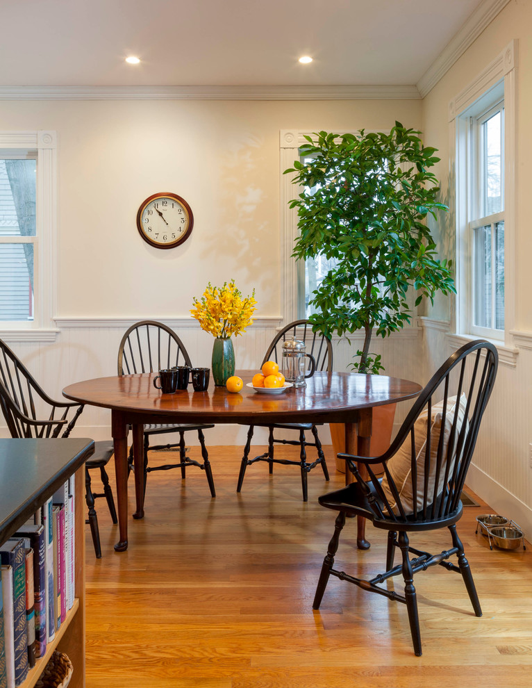 Foto di una piccola sala da pranzo aperta verso la cucina vittoriana con pareti bianche e parquet chiaro