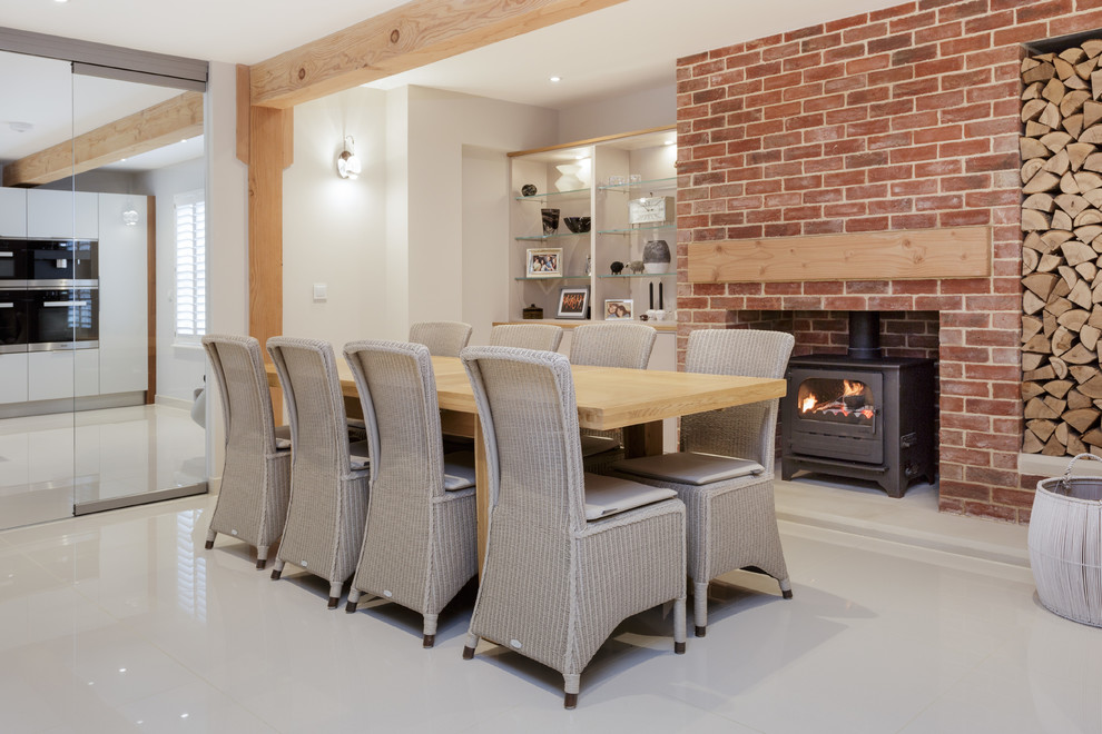 Example of a mid-sized trendy gray floor enclosed dining room design in Other with white walls, a wood stove and a brick fireplace