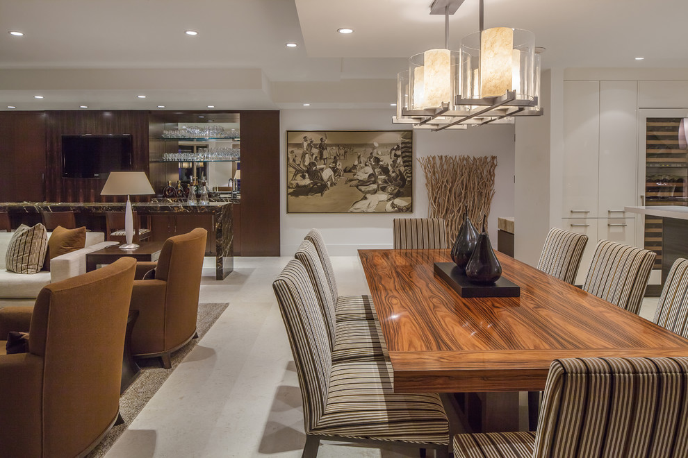This is an example of a large contemporary kitchen/dining room in Miami with white walls, limestone flooring and no fireplace.