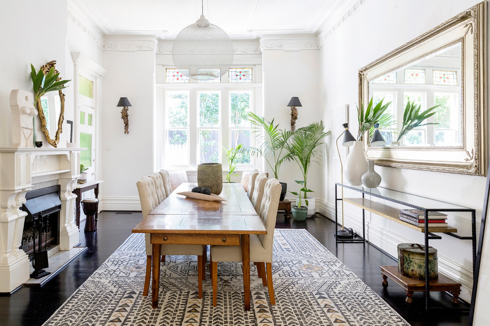 Inspiration for a medium sized traditional dining room in Melbourne with white walls, dark hardwood flooring, a standard fireplace and brown floors.