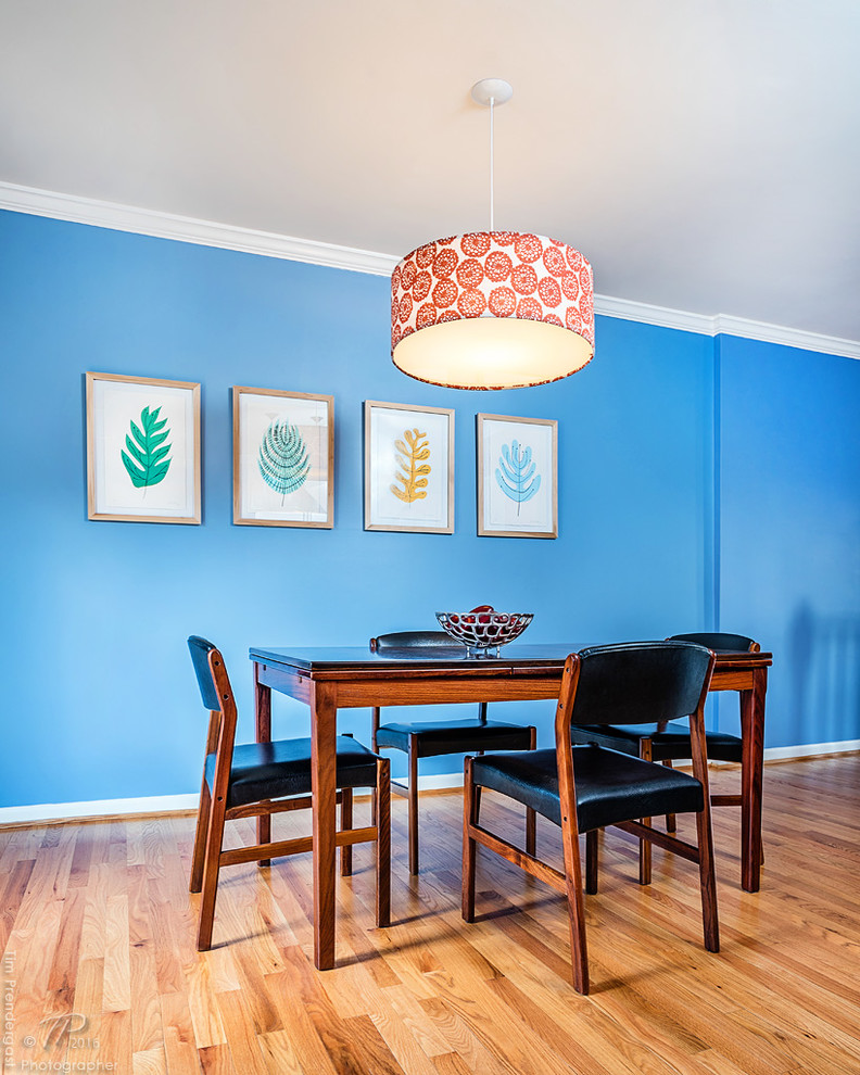 Ispirazione per una sala da pranzo aperta verso la cucina minimalista con pareti blu e parquet chiaro
