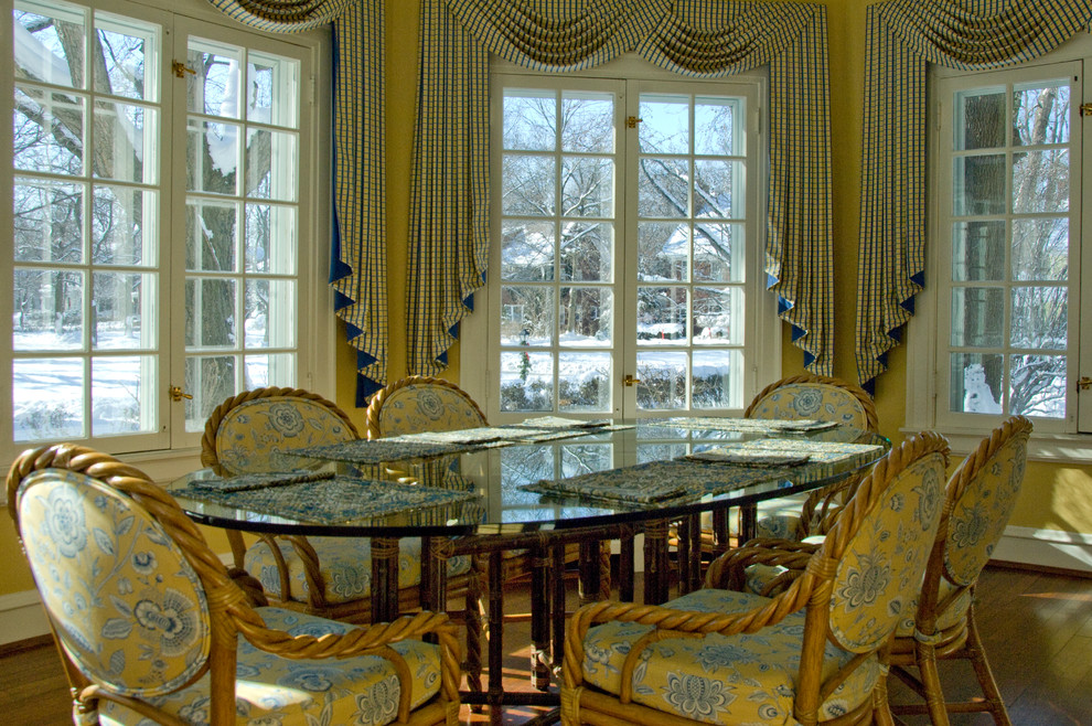 На фото: огромная отдельная столовая в классическом стиле с желтыми стенами и паркетным полом среднего тона