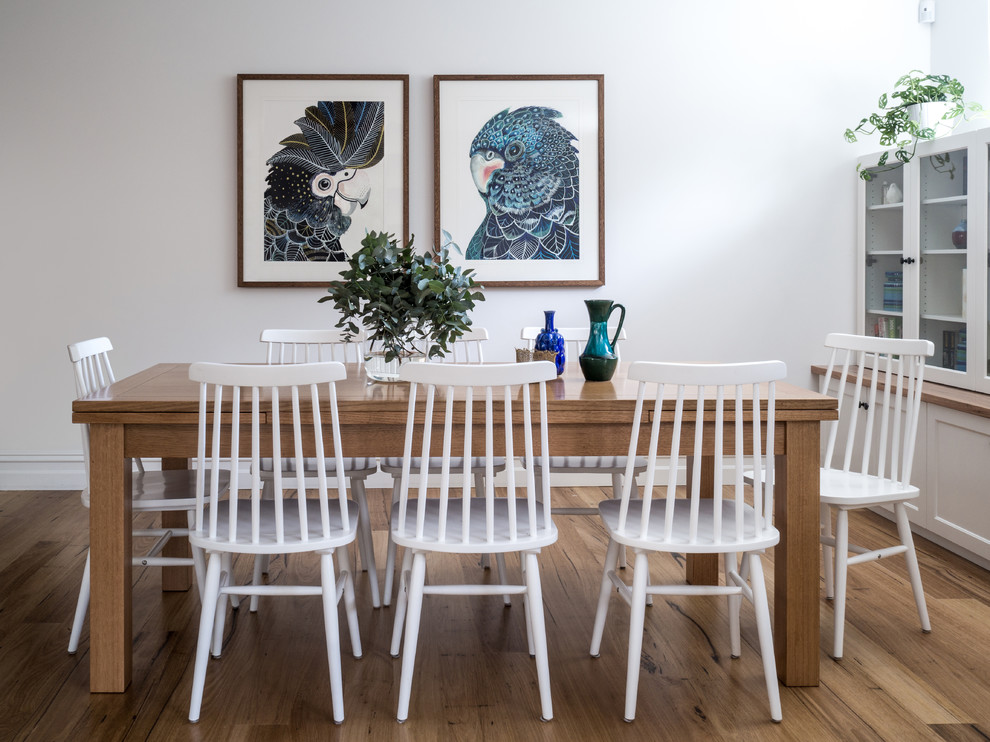 Immagine di una piccola sala da pranzo aperta verso il soggiorno country con pareti bianche, nessun camino, pavimento in legno massello medio e pavimento marrone