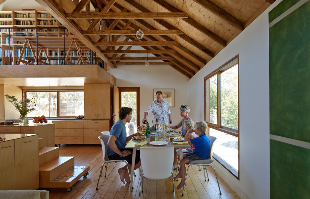 Aménagement d'une petite salle à manger ouverte sur le salon campagne avec un mur blanc et un sol en bois brun.