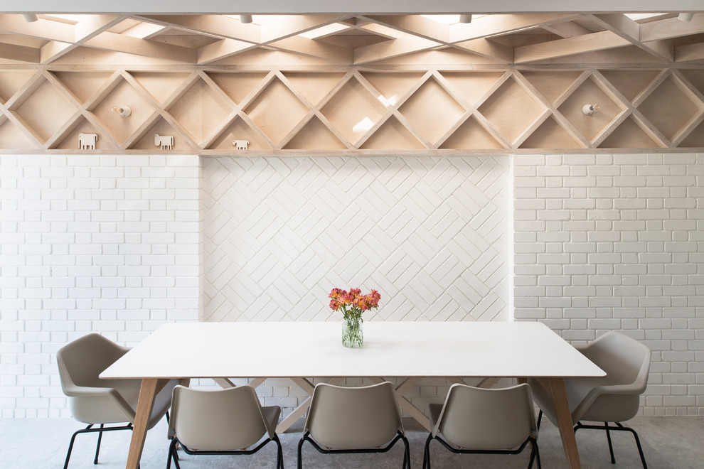Ispirazione per una sala da pranzo contemporanea di medie dimensioni con pareti bianche, pavimento in cemento e pavimento grigio