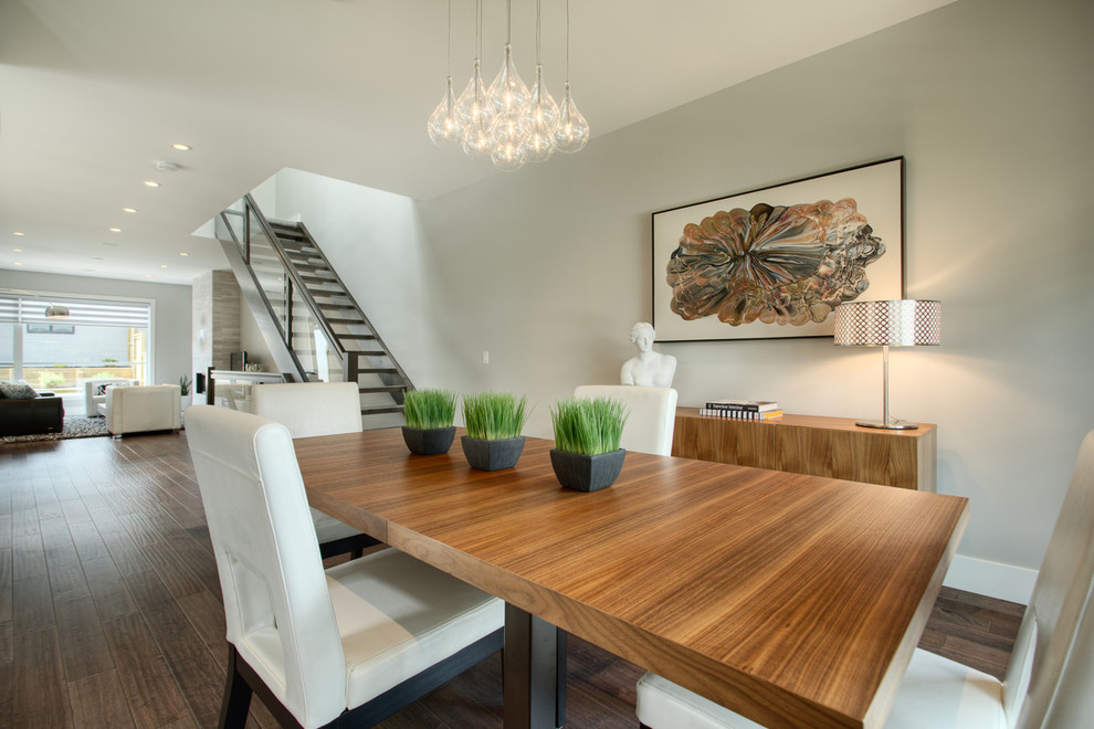 Photo of a contemporary open plan dining room in Calgary with feature lighting.
