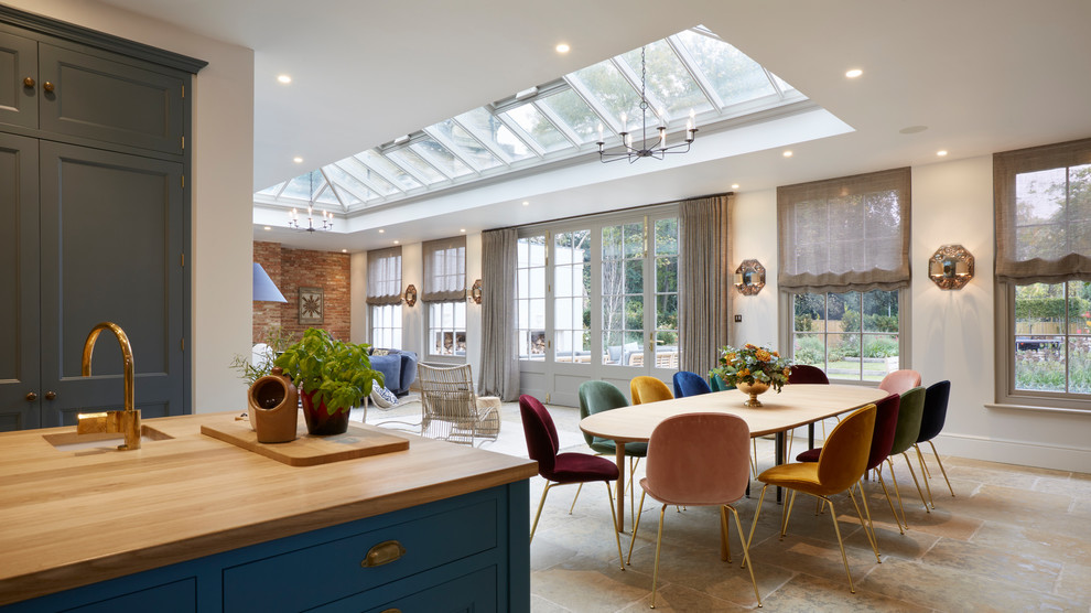 Idee per una sala da pranzo aperta verso il soggiorno tradizionale di medie dimensioni con pavimento in travertino, pareti bianche e pavimento beige
