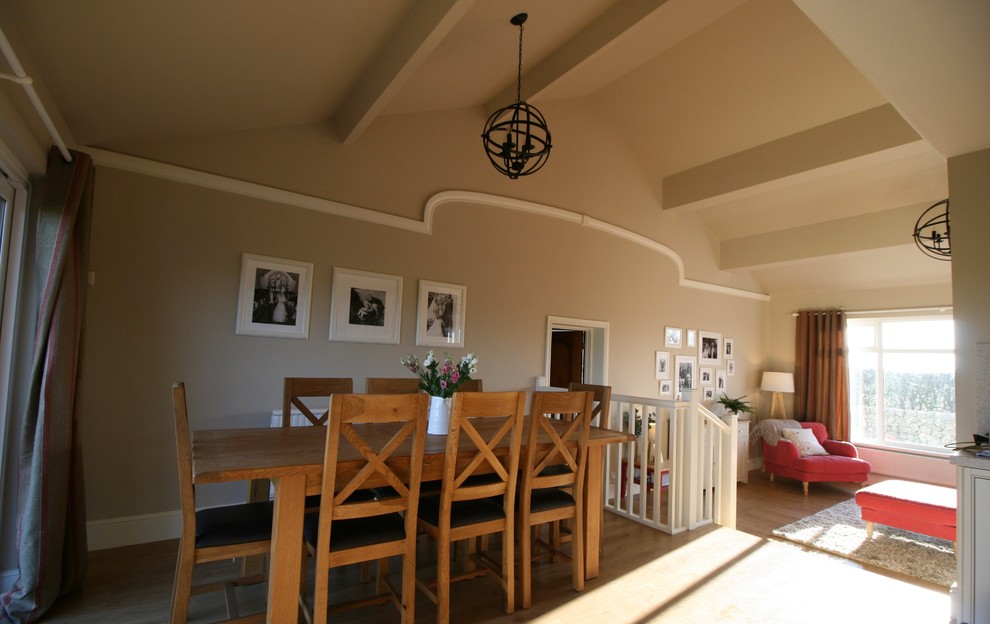 Foto di un'ampia sala da pranzo country con pareti marroni, pavimento in laminato, stufa a legna e cornice del camino in pietra