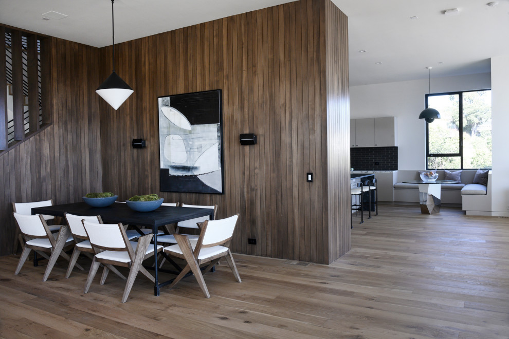 На фото: гостиная-столовая среднего размера в современном стиле с коричневым полом, коричневыми стенами, паркетным полом среднего тона и деревянными стенами с