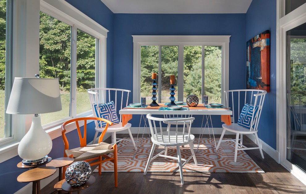 Aménagement d'une salle à manger bord de mer avec un mur bleu, parquet foncé et éclairage.