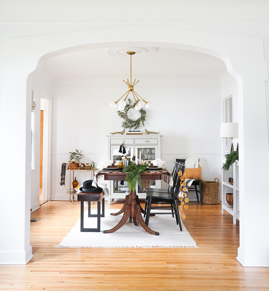 Inspiration for a small scandi enclosed dining room in Minneapolis with white walls, light hardwood flooring, no fireplace and brown floors.