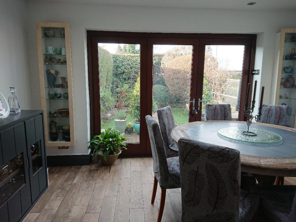 Exemple d'une salle à manger ouverte sur la cuisine tendance de taille moyenne avec un mur blanc, un sol en carrelage de céramique, aucune cheminée et un sol marron.