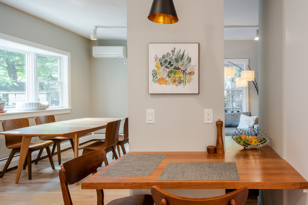 Aménagement d'une salle à manger contemporaine avec une banquette d'angle, un mur gris et parquet clair.