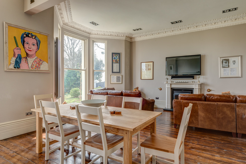 Foto di una grande sala da pranzo aperta verso la cucina country con pareti beige e pavimento in legno massello medio