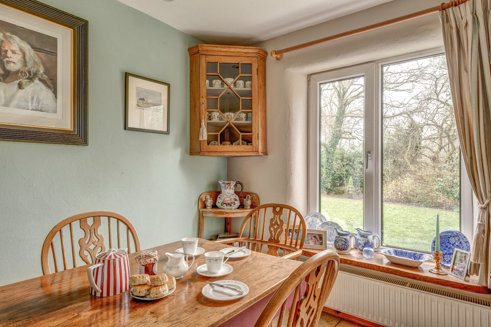 Ejemplo de comedor de cocina campestre de tamaño medio con paredes azules y suelo de baldosas de cerámica