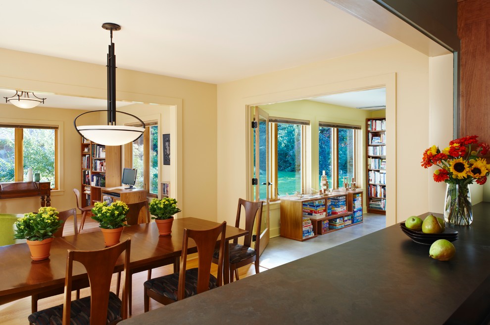 Esempio di una sala da pranzo aperta verso il soggiorno american style di medie dimensioni con pareti gialle, pavimento in legno massello medio e pavimento beige