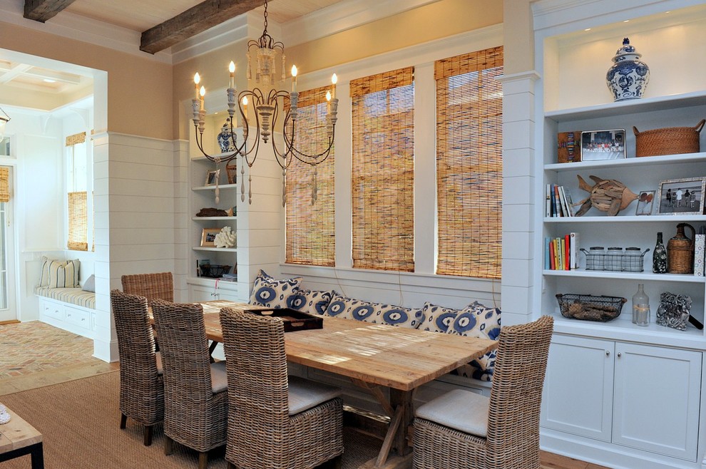 Immagine di una sala da pranzo aperta verso la cucina stile marino di medie dimensioni con pareti gialle e pavimento in legno massello medio