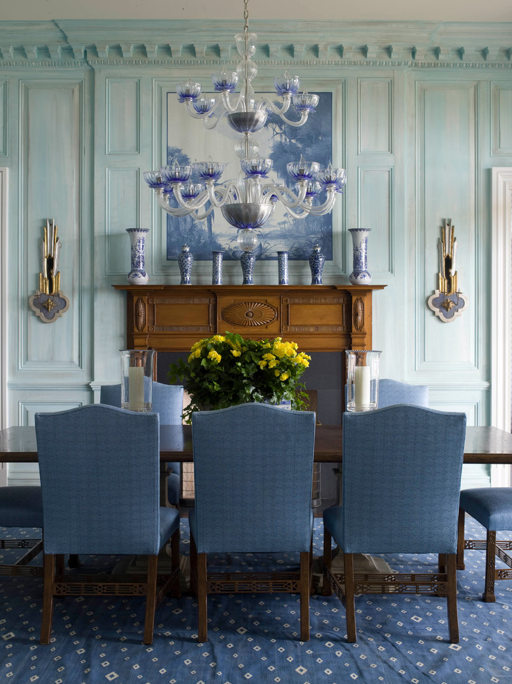 Esempio di una grande sala da pranzo aperta verso il soggiorno stile marino con pareti blu, parquet scuro, camino classico e cornice del camino in legno