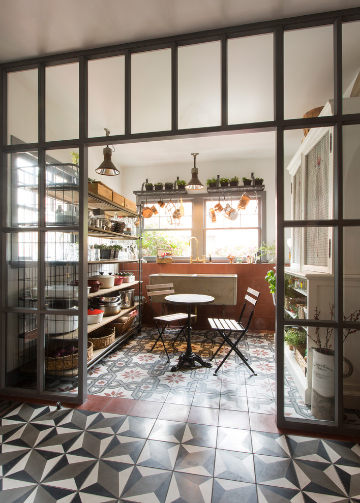 Small industrial enclosed dining room in Los Angeles with ceramic flooring and feature lighting.