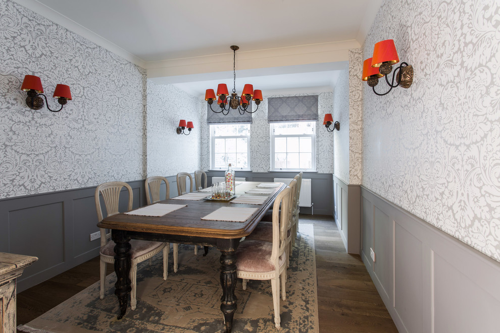 Idée de décoration pour une grande salle à manger design fermée avec un sol en bois brun et un mur gris.