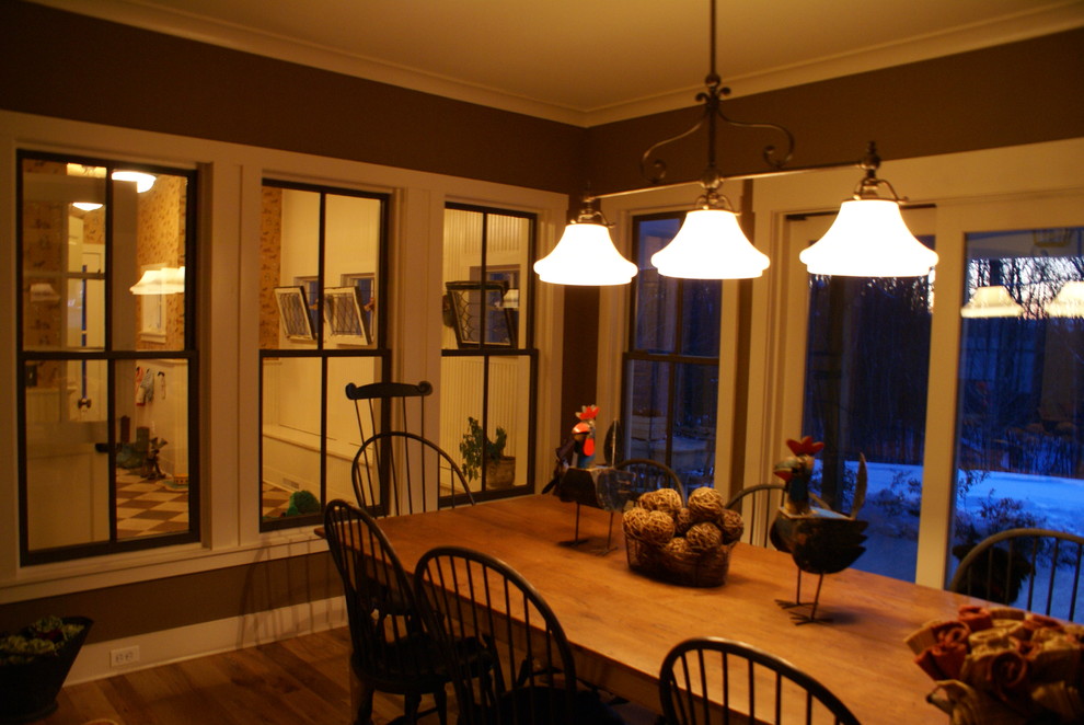 Réalisation d'une salle à manger ouverte sur la cuisine tradition de taille moyenne avec un mur marron et un sol en bois brun.