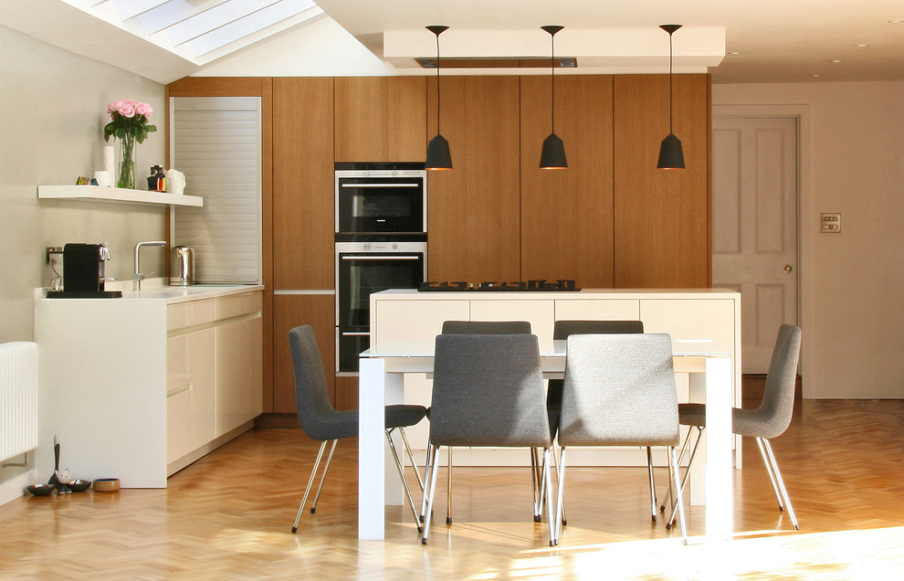 Idées déco pour une salle à manger ouverte sur la cuisine contemporaine avec un mur gris, un sol en bois brun et aucune cheminée.