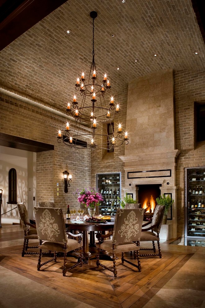 Inspiration for a mediterranean dining room in Orange County with a stone fireplace surround and a standard fireplace.