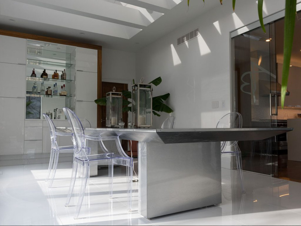 Imagen de comedor minimalista de tamaño medio abierto con paredes blancas y suelo blanco