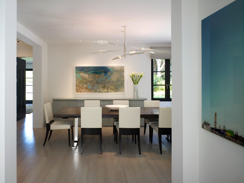 Example of a large trendy light wood floor dining room design in Los Angeles with white walls and no fireplace