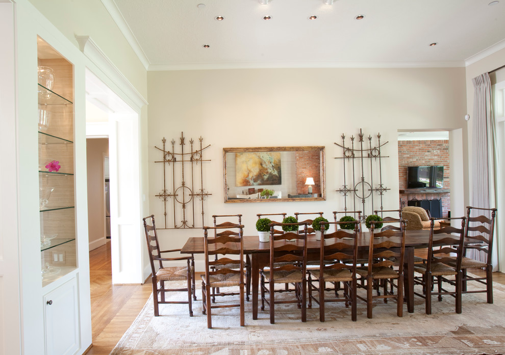 Aménagement d'une grande salle à manger ouverte sur le salon classique avec un mur beige et un sol en bois brun.