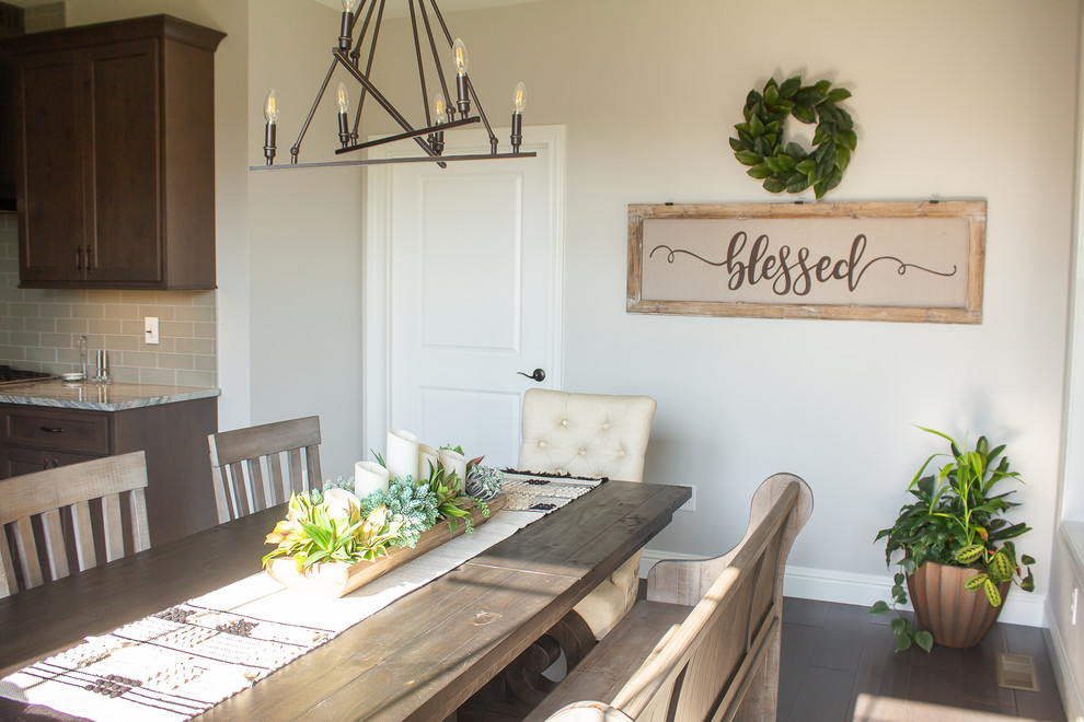 Cette image montre une salle à manger ouverte sur la cuisine rustique de taille moyenne avec un mur beige, un sol en bois brun et un sol marron.