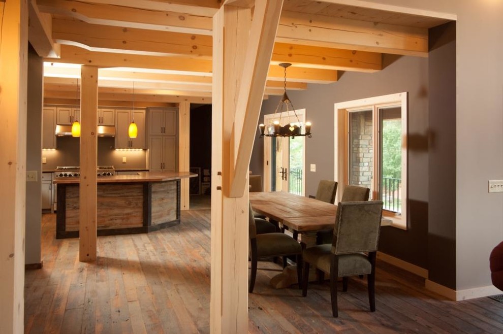 Inspiration pour une salle à manger ouverte sur la cuisine chalet avec un sol en bois brun.