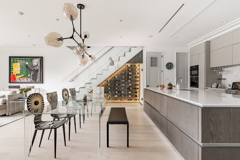 Cette image montre une salle à manger ouverte sur le salon design de taille moyenne avec un mur blanc, parquet clair, aucune cheminée et un sol beige.