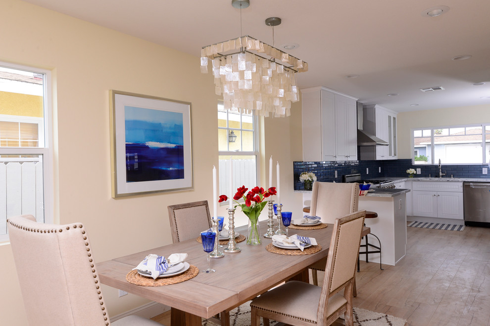 Inspiration pour une salle à manger ouverte sur la cuisine marine avec un mur beige et parquet clair.