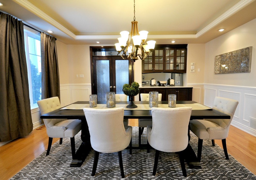Aménagement d'une grande salle à manger ouverte sur la cuisine classique avec un mur beige, un sol en bois brun et aucune cheminée.