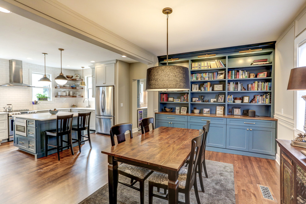 Foto di una sala da pranzo aperta verso la cucina classica di medie dimensioni con pareti beige, pavimento in vinile, pavimento marrone e nessun camino